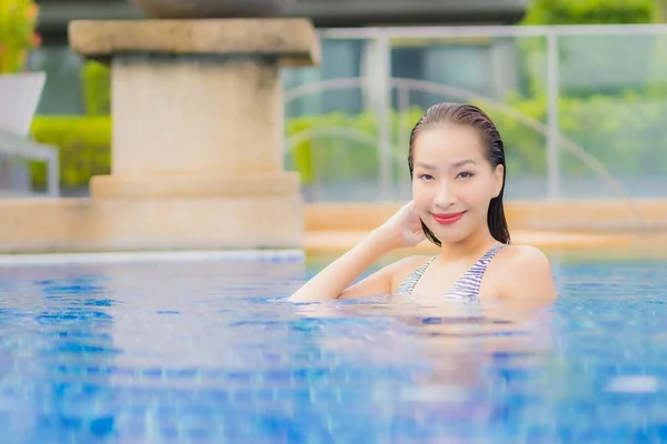 美丽动人的年轻亚洲女人度假时 在酒店度假胜地的室外游泳池边 放松地笑个好觉 — 图库照片