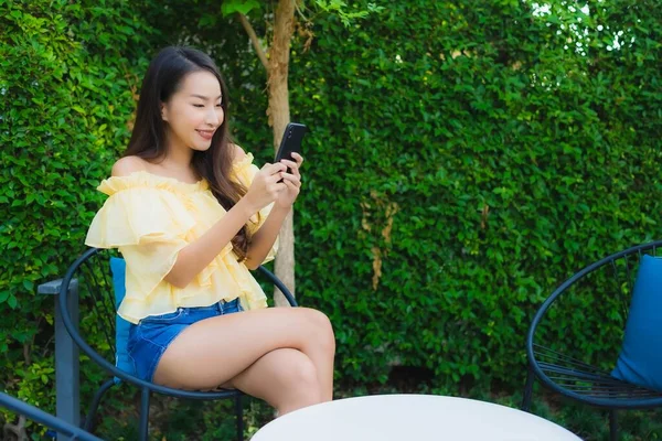 Genç Asyalı kadın açık hava manzarası için akıllı cep telefonu kullanıyor.