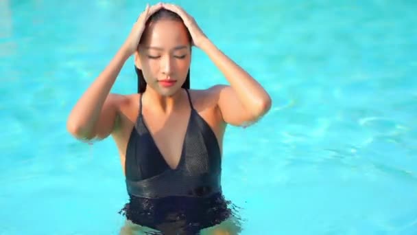 ポートレート美しい若いアジアの女性は ホテルのリゾートでスイミングプールの周りのレジャーをリラックス — ストック動画