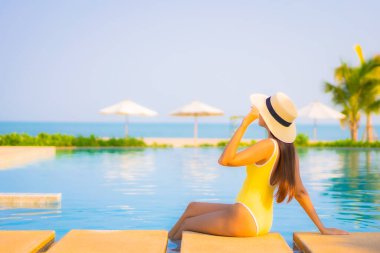Güzel bir Asyalı kadın portresi. Rahatlayın, gülümseyin. Tatil için oteldeki yüzme havuzunun keyfini çıkarın.