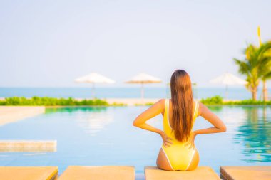 Güzel bir Asyalı kadın portresi. Rahatlayın, gülümseyin. Tatil için oteldeki yüzme havuzunun keyfini çıkarın.