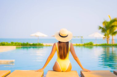 Güzel bir Asyalı kadın portresi. Rahatlayın, gülümseyin. Tatil için oteldeki yüzme havuzunun keyfini çıkarın.