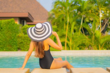 Güzel bir Asyalı kadın portresi. Rahatlayın, gülümseyin. Tatil için oteldeki yüzme havuzunun keyfini çıkarın.