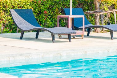 Şemsiye ve sandalye oteldeki yüzme havuzunda, okyanus kıyısına yakın bir yerde.