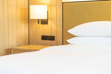 Yatak odasının iç dekorasyonuna beyaz yastık ve battaniye.