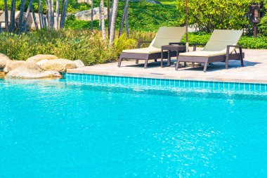 Açık yüzme havuzu, deniz kıyısı, şemsiye ve tatil için sandalye.