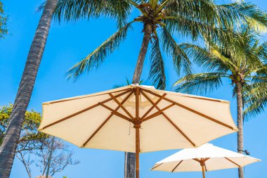 Boş güverte sandalyesi şemsiyesi ile sahil kıyısı okyanus mavi gökyüzü tatil için