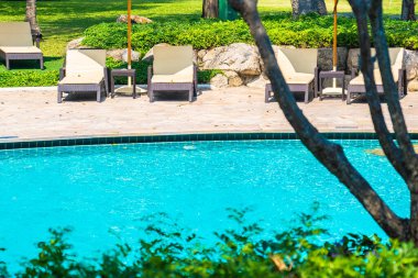 Açık yüzme havuzu, deniz kıyısı, şemsiye ve tatil için sandalye.