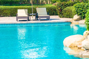 Açık yüzme havuzu, deniz kıyısı, şemsiye ve tatil için sandalye.