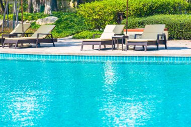 Açık yüzme havuzu, deniz kıyısı, şemsiye ve tatil için sandalye.