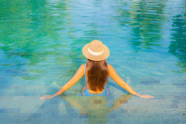 Güzel bir Asyalı kadın portresi. Rahatlayın. Yüzme havuzunun, deniz kenarındaki okyanus manzarasının keyfini çıkarın.