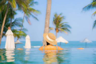 Güzel bir Asyalı kadın portresi. Rahatlayın. Yüzme havuzunun, deniz kenarındaki okyanus manzarasının keyfini çıkarın.