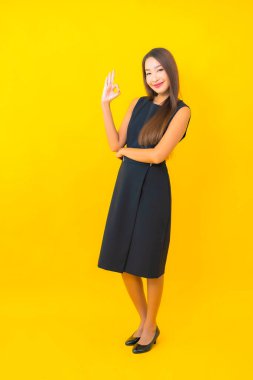 Güzel Asyalı iş kadını portresi. Sarı arka planda hareketli bir gülümseme.