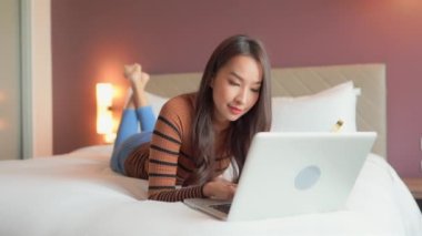 Evde dizüstü bilgisayarla çalışan Asyalı güzel bir kadının görüntüleri.