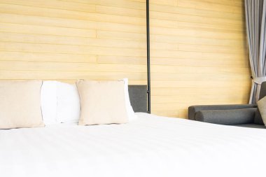 Otel odasındaki yatak odasının iç dekorasyonunda beyaz rahat yastık.