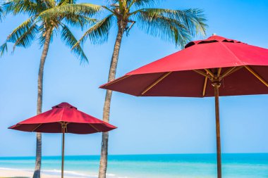 Boş güverte sandalyesi şemsiyesi ile sahil kıyısı okyanus mavi gökyüzü tatil için