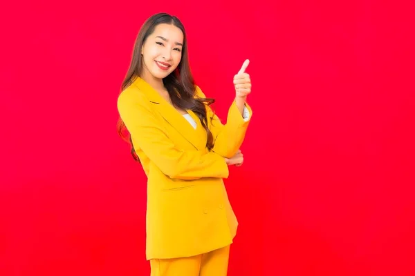 Portrait beautiful young business asian woman smile with action on red isolated background