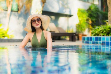 Güzel bir Asyalı kadın portresi. Tatilde dinlenmek için otel havuzunda dinleniyor.