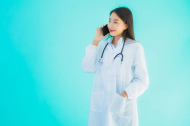 Güzel bir Asyalı doktor portresi. Klinik ya da hastane için cep telefonu kullanıyor.