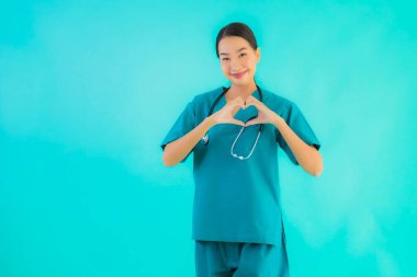 Güzel bir Asyalı genç doktor portresi. Mutlu bir gülümseme. Hastane ve klinikte çalışmak için kalp şeklini göster.