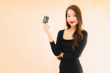 Renkli arka planda alışveriş yapmak için kredi kartı olan güzel bir Asyalı kadın portresi.