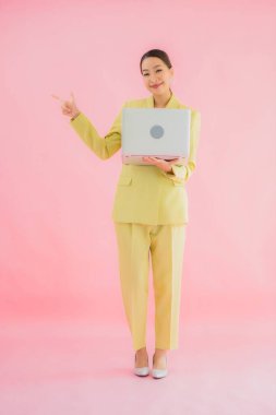 Güzel Asyalı iş kadını portresi renk arkaplanda bilgisayar bilgisayarı kullanıyor