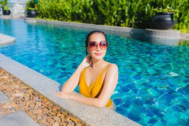 Güzel bir Asyalı kadın portresi. Rahatlayın. Keyifli bir tatil için oteldeki yüzme havuzunda mutlu bir gülümseme.