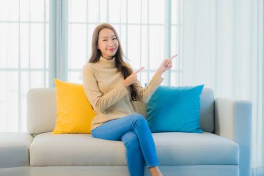 Güzel bir Asyalı kadın portresi. Rahat ol. Oturma odasının iç kısmındaki kanepede keyfine bak.