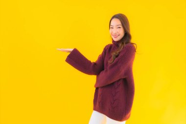 Güzel Asyalı kadın gülümsüyor. Sarı izole edilmiş arka planda başka bir eylemde mutlu.