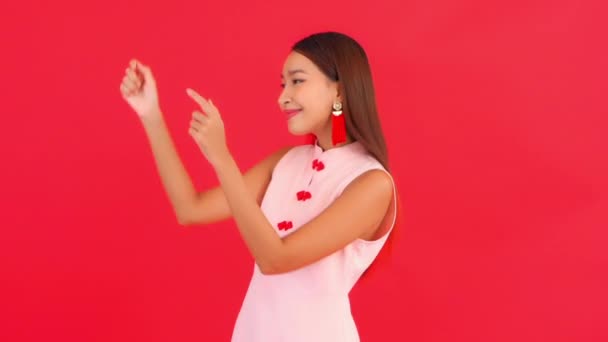 Zdjęcia Pięknej Młodej Azjatyckiej Kobiety Stylowych Ubraniach Czerwonym Tle Wskazując — Wideo stockowe