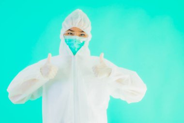 Güzel, genç Asyalı doktor kadın portre. Koronavirüsten ya da mavi arka planda kovid19 'dan korunmak için ppe ya da kişisel koruyucu ekipman takıyor.