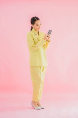 Güzel Asyalı iş kadını portresi. Arka planda kahve fincanı ve akıllı cep telefonu kullanıyor.