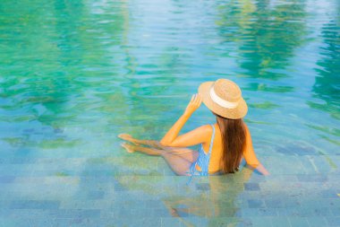 Güzel bir Asyalı kadın portresi. Rahatlayın. Yüzme havuzunun, deniz kenarındaki okyanus manzarasının keyfini çıkarın.