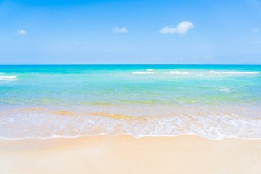 Yolculuk için beyaz bulutlu ve mavi gökyüzü arka planlı güzel tropikal deniz okyanusu