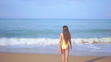 Güzel Asyalı kadının tatilde deniz kıyısındaki görüntüleri.