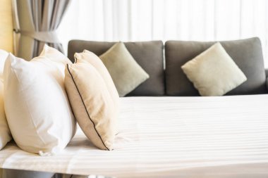 Otel odasındaki yatak odasının iç dekorasyonunda beyaz rahat yastık.