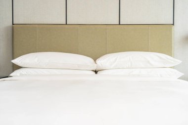 Yatak odasının içi beyaz, rahat yastık ve battaniye dekorasyonu.