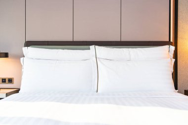 Yatak odasının iç kısımlarında beyaz rahat yastık ve battaniye.