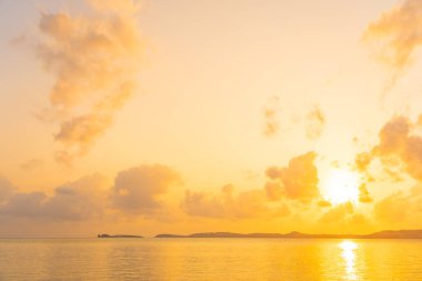 Günbatımında bulutlu ve gökyüzü olan güzel tropikal deniz okyanusu ya da seyahat ve tatil için gün doğumu zamanı