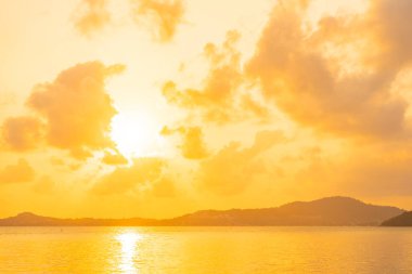 Günbatımında bulutlu ve gökyüzü olan güzel tropikal deniz okyanusu ya da seyahat ve tatil için gün doğumu zamanı