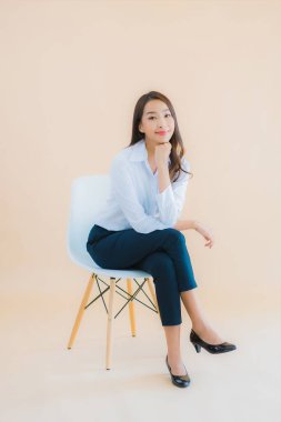 Güzel bir iş kadını portresi. Sandalyeye dizüstü bilgisayarı ya da iş için akıllı telefonu olan bir kadın.