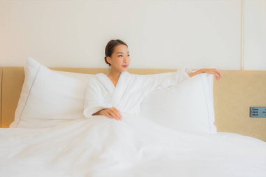 Güzel bir Asyalı kadın portresi. Rahatlayın, gülümseyin. Yatak odasında dinlenin.