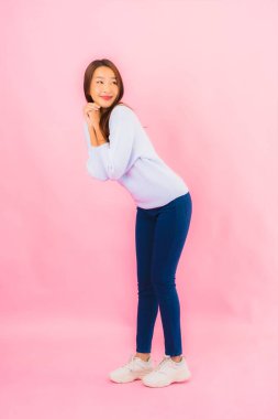 Portrait beautiful young asian woman smile with action on pink isolated background