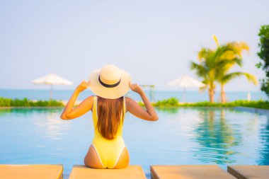 Güzel bir Asyalı kadın portresi. Rahatlayın, gülümseyin. Tatil için oteldeki yüzme havuzunun keyfini çıkarın.