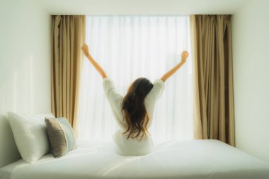 Genç Asyalı mutlu gülümseme. Yatak odasında iç tarafta rahatla.