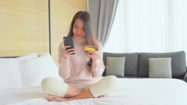 Güzel Asyalı kadının evde akıllı telefon kullandığının görüntüleri.