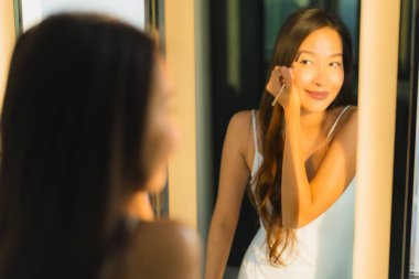 Güzel bir Asyalı kadın portresi makyaj malzemesi makyaj malzemesi ve yüz makyajı ile banyo içinde yüz maskesi.