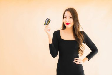 Renkli arka planda alışveriş yapmak için kredi kartı olan güzel bir Asyalı kadın portresi.