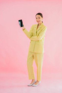 Güzel Asyalı iş kadını portresi. Arka planda kahve fincanı ve akıllı cep telefonu kullanıyor.