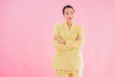 Portre güzel Asyalı genç iş kadını pembe arka planda gülümsüyor